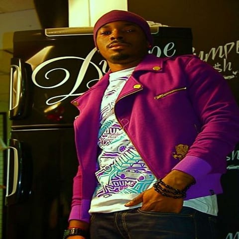 Ab Del Castro en veste violette devant un décor du label Divine Style